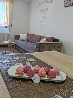a tray of pink frosted donuts on a table at APARTMAN ANDREA in Leskovac