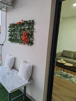 a living room with a plant on the wall at APARTMAN ANDREA in Leskovac