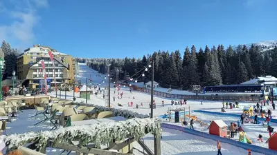 a ski resort with people on a ski slope at Apartman MK Kopaonik in Kopaonik
