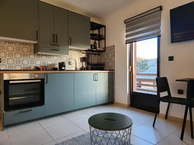 a kitchen with blue cabinets and a table and a window at Detelina in Kopaonik