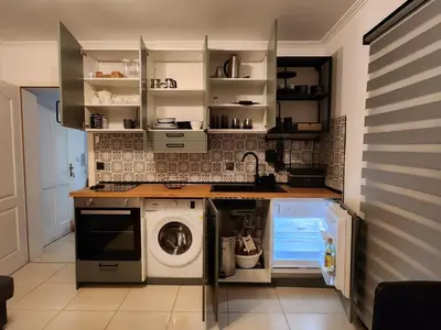 a kitchen with a washer and a washing machine at Detelina in Kopaonik