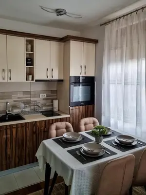 a kitchen with a table with chairs and a microwave at Apartman Nevena in Vrnjačka Banja