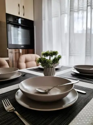 a dining room table with plates and utensils on it at Apartman Nevena in Vrnjačka Banja