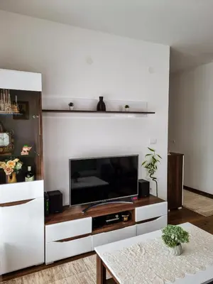 a living room with a large television and a table at Apartman Nevena in Vrnjačka Banja