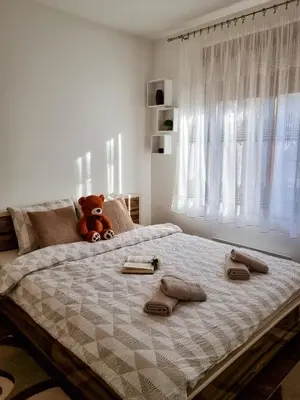a teddy bear sitting on top of a bed at Apartman Nevena in Vrnjačka Banja