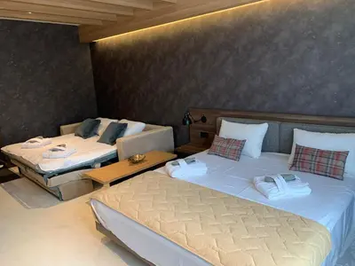 a room with two beds and a table in it at Woodside Kopaonik - Malo jezero, FREE Parking & SPA in Kopaonik