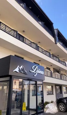 a building with a car parked in front of it at Lukić Apartmani in Kopaonik