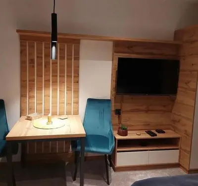 a dining room with a table and a blue chair at Lukić Apartmani in Kopaonik