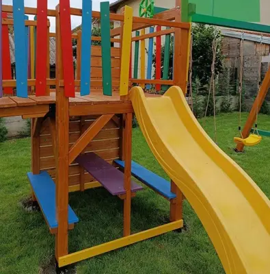 a wooden play set with a slide in a yard at ETNO Selo STRAŽA in Pirot