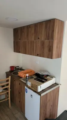 a kitchen with wooden cabinets and a white refrigerator at ETNO Selo STRAŽA in Pirot