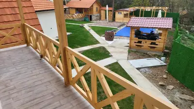 a backyard with a wooden deck and a playground at ETNO Selo STRAŽA in Pirot