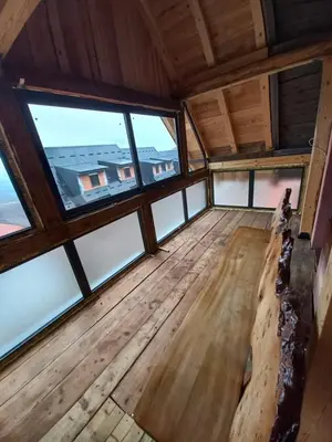 an empty room with large windows in a cabin at Vikend kuća Vukašinović in Kopaonik