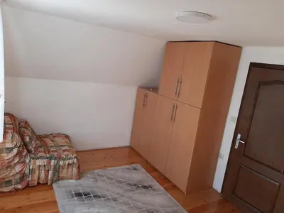 a bedroom with a bed and a cabinet and a floor at Vikend kuća Vukašinović in Kopaonik