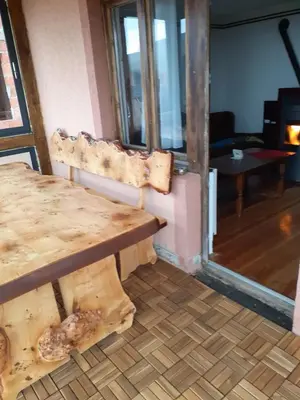 a room with a wooden table and a wooden bench at Vikend kuća Vukašinović in Kopaonik
