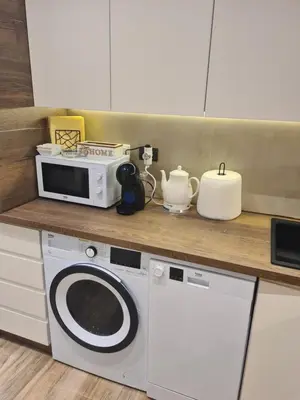 a kitchen with a washing machine and a microwave at Dajoda Lux - free Spa in Kopaonik