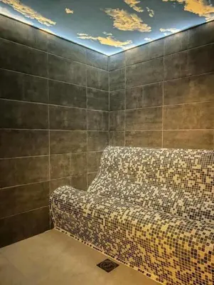 a couch sitting in a room with a wall at Dajoda Lux - free Spa in Kopaonik