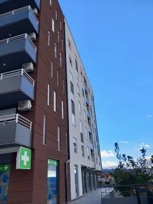 a tall building with a green cross on it at Apartman Petra in Niš