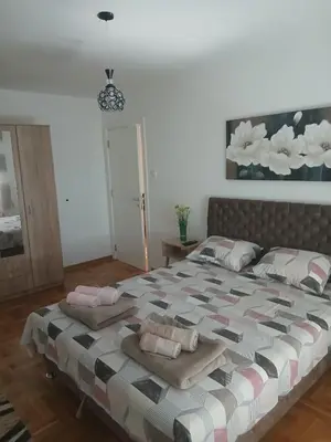 a bedroom with a large bed with pillows on it at Apartman Petra in Niš