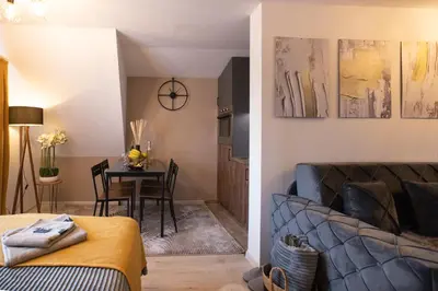 a bedroom and a living room with a couch and a table at Velickovic Alibi in Kopaonik