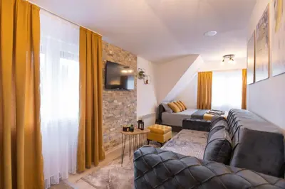 a living room with a couch and a tv at Velickovic Alibi in Kopaonik