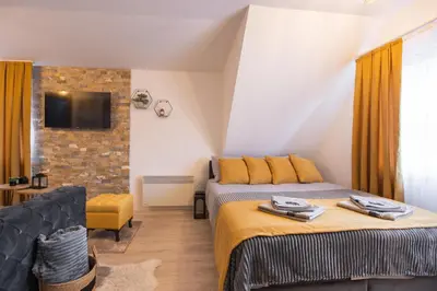 a bedroom with two beds and a tv on the wall at Velickovic Alibi in Kopaonik