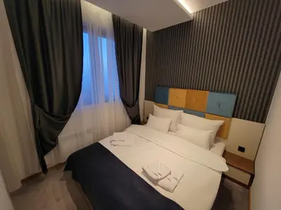 a bedroom with a bed with two shoes on it at Three Pearls in Kopaonik