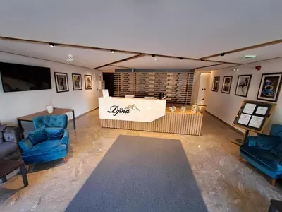a living room with two blue chairs and a table at Three Pearls in Kopaonik