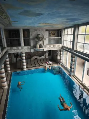a large swimming pool with people swimming in it at Sokoterme Hotel in Soko Banja