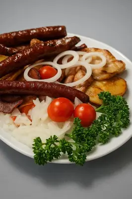 a plate of breakfast food with sausage and tomatoes at Sokoterme Hotel in Soko Banja