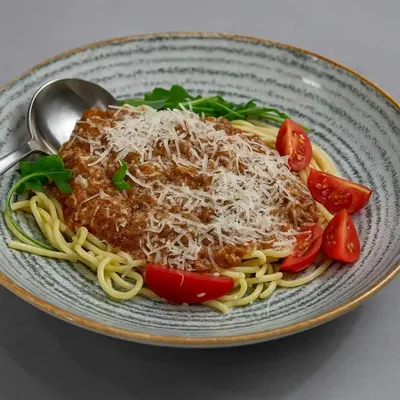 a plate of spaghetti with meat sauce and cheese at Sokoterme Hotel in Soko Banja