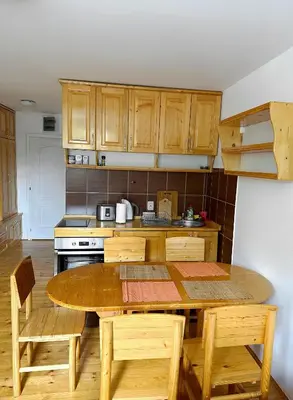 a kitchen with a wooden table and wooden cabinets at Brzeće - Bele staze Nikola in Brzeće