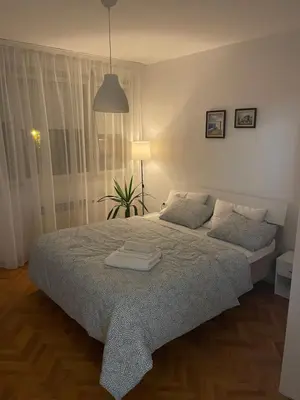 a bedroom with a large bed and a window at Dora apartment in Niš