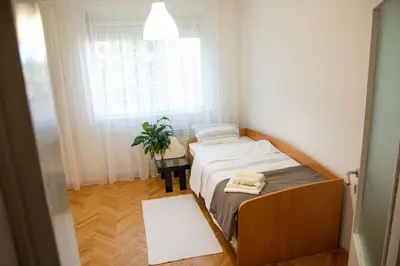 a small bedroom with a bed and a window at Dora apartment in Niš