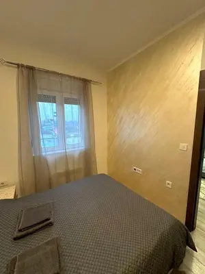 a bedroom with a bed and a window at apartmanjagodinaana in Jagodina
