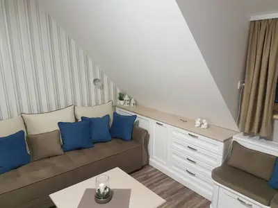 a living room with a couch and blue pillows at Apartman Maglic 412 Lux in Kopaonik