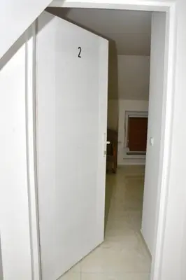 a white door in a room with a hallway at Grof apartmani in Zaječar