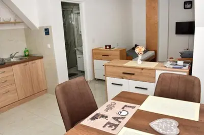 a kitchen with a table and a dining room at Grof apartmani in Zaječar