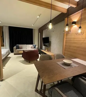 a living room with a dining table and a couch at Woodside Kopaonik By Gogic in Kopaonik