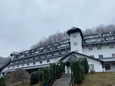 a large white building with trees in front of it at Bele Staze 3a Kopaonik, Brzece in Kopaonik