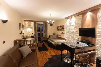 a living room with a couch and a bed at Apartman W Residence in Kopaonik