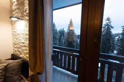 a room with a window with a view of the snow covered trees at Apartman W Residence in Kopaonik