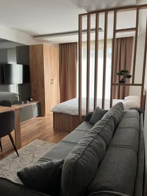 a living room with a couch and a bed at President Kop Fibi in Kopaonik