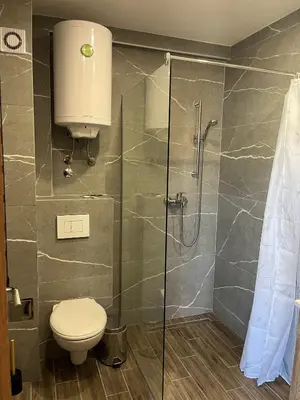 a bathroom with a toilet and a glass shower at President Kop Fibi in Kopaonik