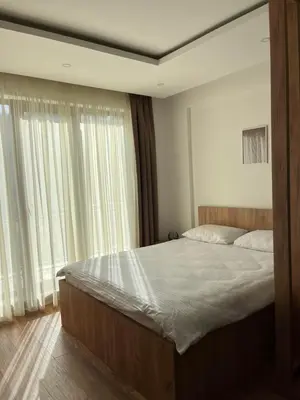 a bedroom with a large bed and a large window at President Kop Fibi in Kopaonik