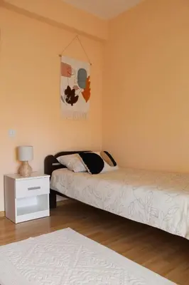 a bedroom with two beds and a night stand with a lamp at Miss apartman in Jagodina