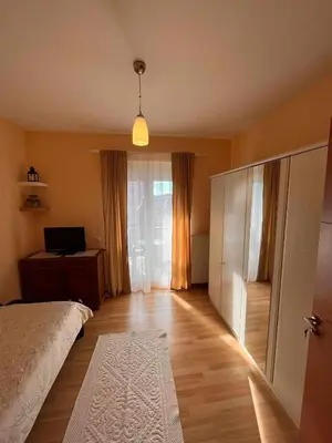 a bedroom with a bed and a desk with a laptop at Miss apartman in Jagodina