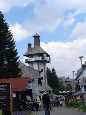a man walking past a building with a sign on it at Apt. Kop for you in Kopaonik