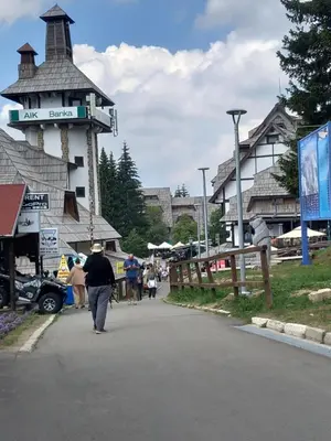a woman walking down a street next to a building at Apt. Kop for you in Kopaonik