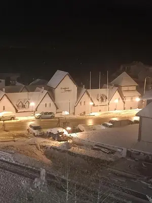 a group of buildings at night with cars in a parking lot at Apt. Kop for you in Kopaonik
