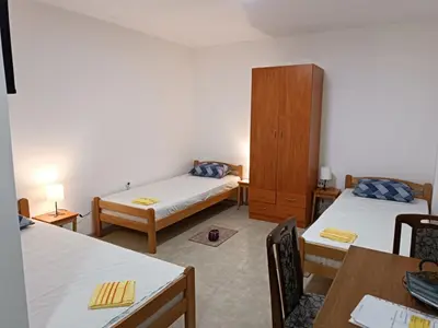 a room with two beds and a wooden cabinet at Adamovic in Pirot
